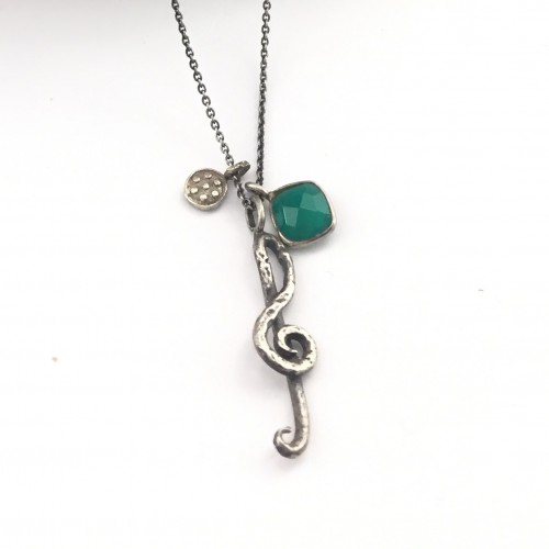 Silver chain with musical treble clef pendant and natural stone.